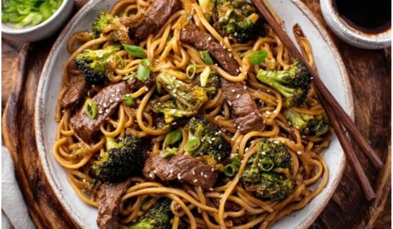 Beef and Broccoli Lo Mein Noodles served with chopsticks on a rustic plate
