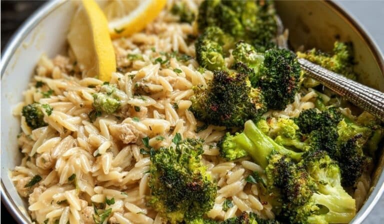 Quick Ground Turkey Orzo with roasted broccoli and lemon wedge in a white bowl