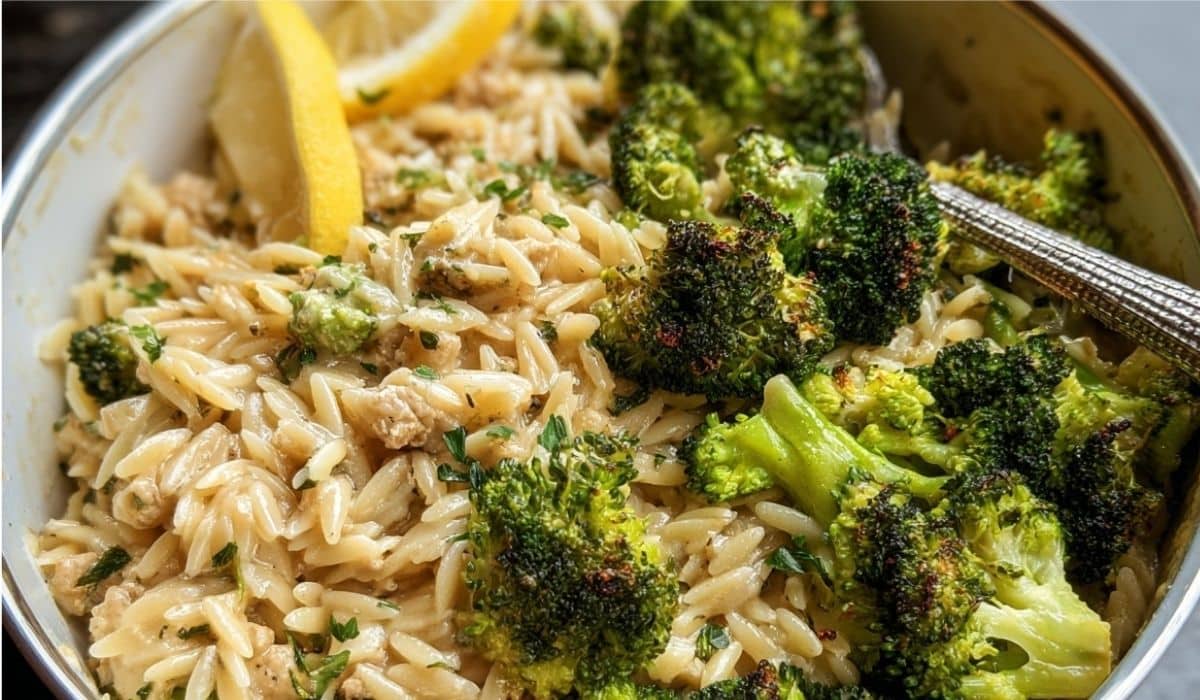 Quick Ground Turkey Orzo with roasted broccoli and lemon wedge in a white bowl