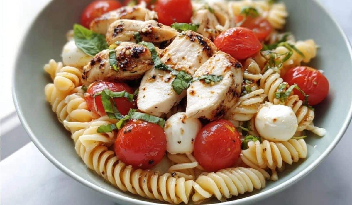 Caprese Pasta with Rotisserie Chicken served in a bowl with cherry tomatoes, mozzarella, and basil