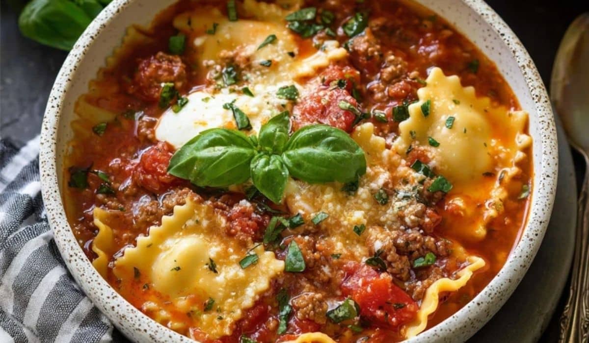 Crockpot Lasagna Soup topped with basil and parmesan in a white bowl
