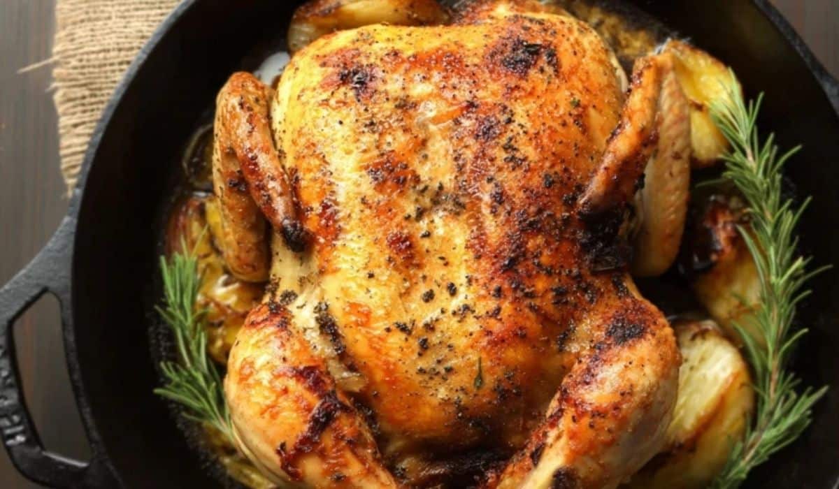 Easy Cast Iron Whole Roasted Chicken in skillet with rosemary and garlic