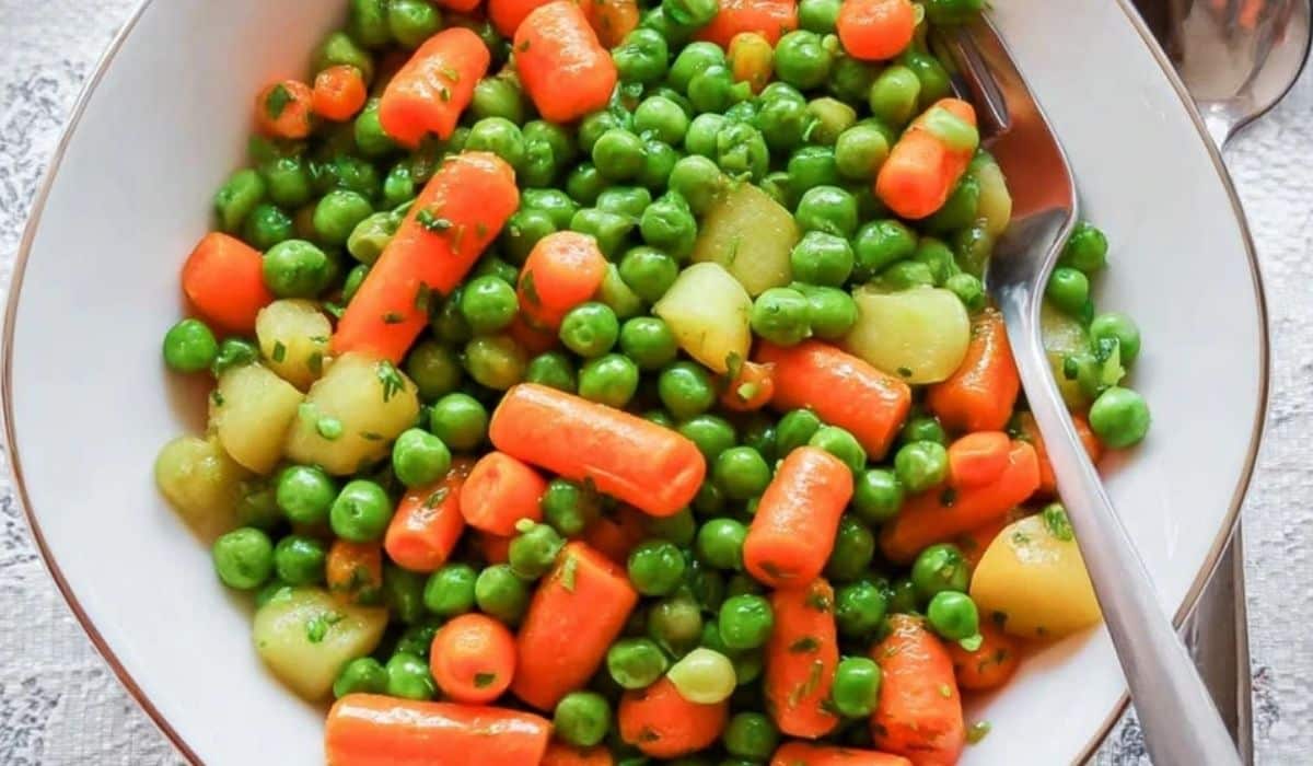 One pan peas and carrots in white bowl with potatoes