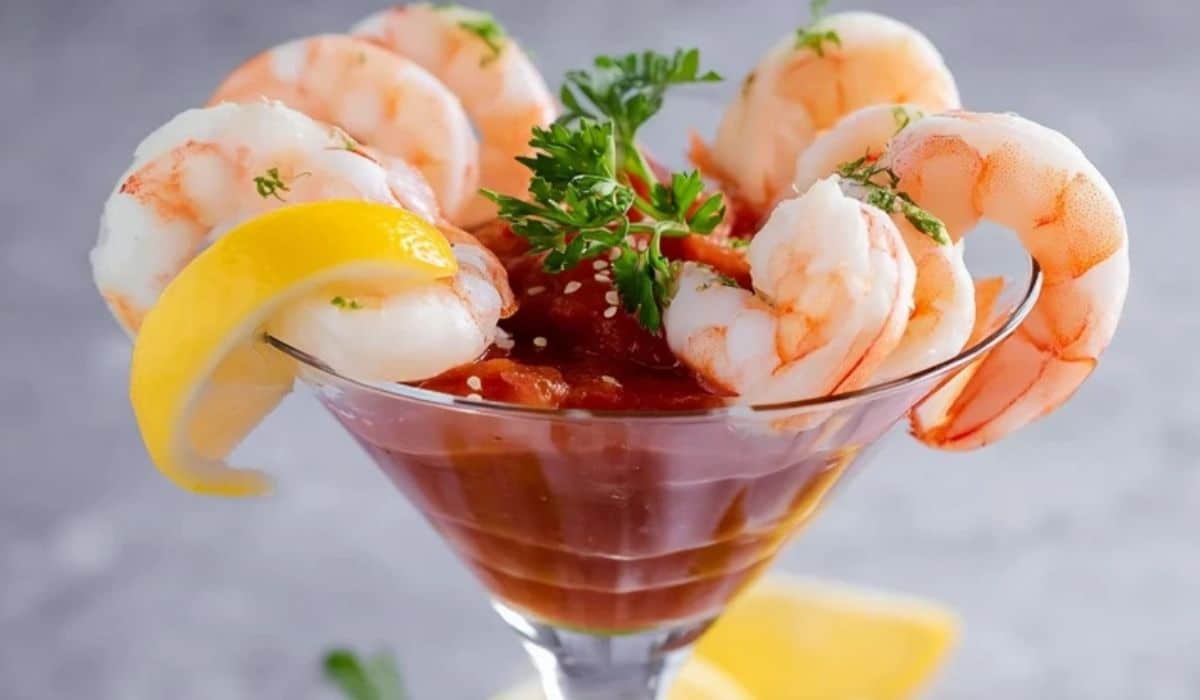 Classic Shrimp Cocktail served in a martini glass with lemon garnish and cocktail sauce
