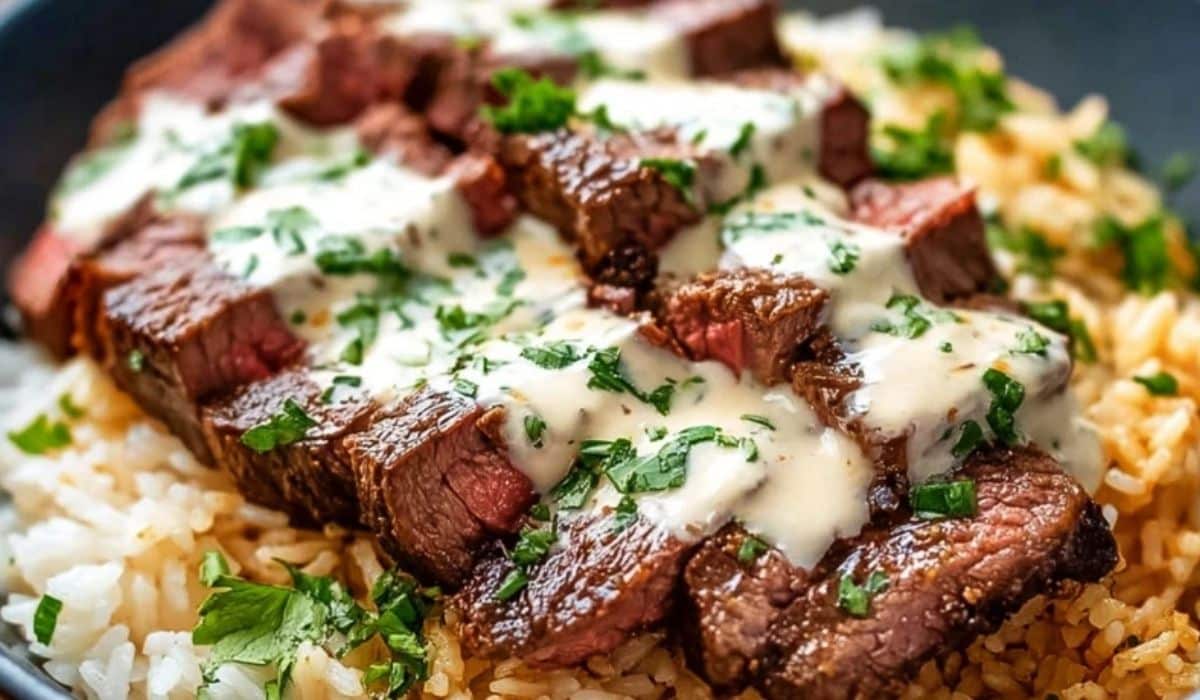Steak and Queso Rice with creamy queso sauce over tender steak slices and fluffy rice
