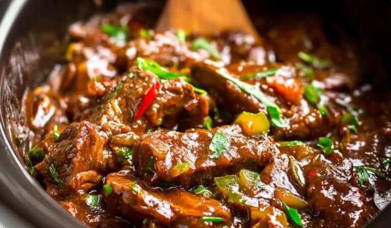Crock Pot Pepper Steak simmering in a slow cooker with peppers and beef