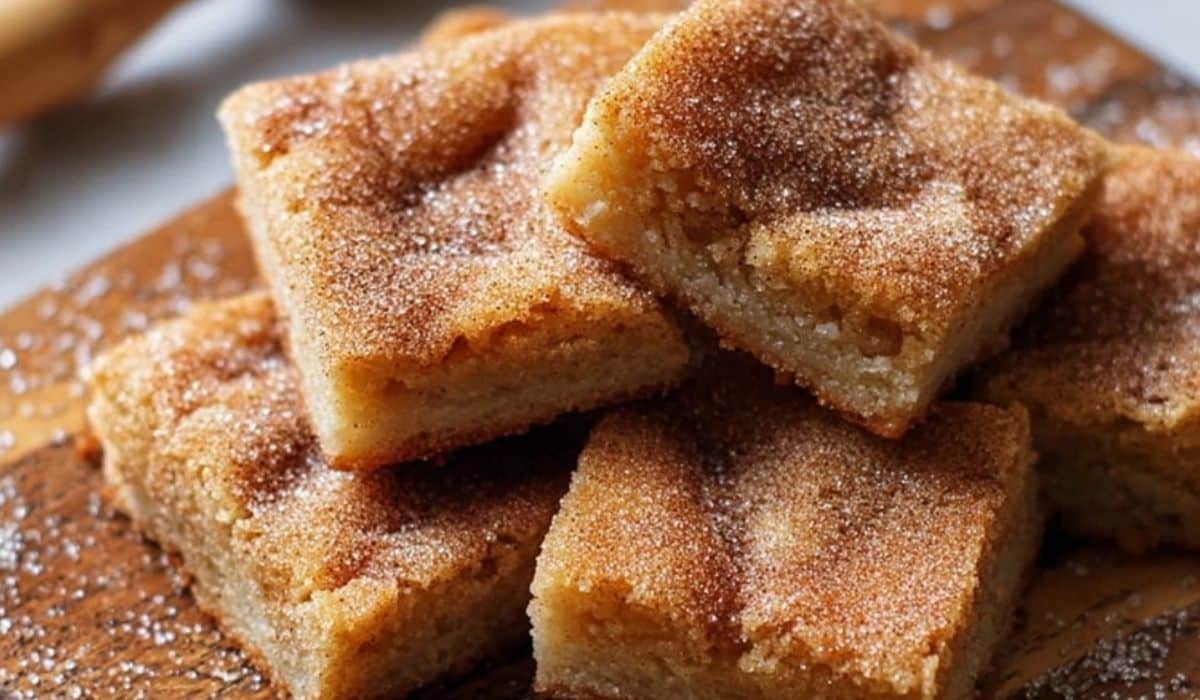 Easy Cinnamon Sugar Blondies stacked on parchment paper with visible cinnamon sugar topping
