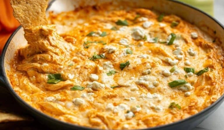 Classic Buffalo Chicken Dip served hot in a cast iron skillet with tortilla chip