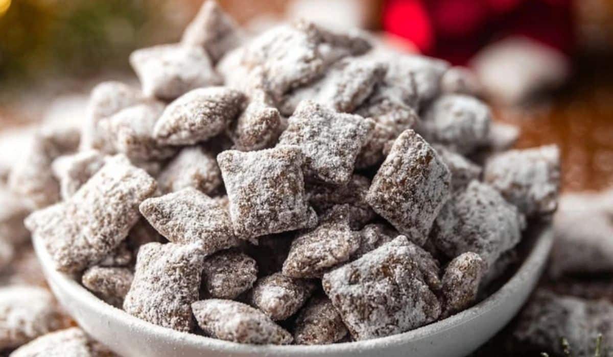 Midwestern Puppy Chow in a white bowl covered with powdered sugar