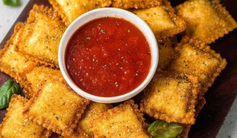 Fried Ravioli with marinara dip on a wooden board