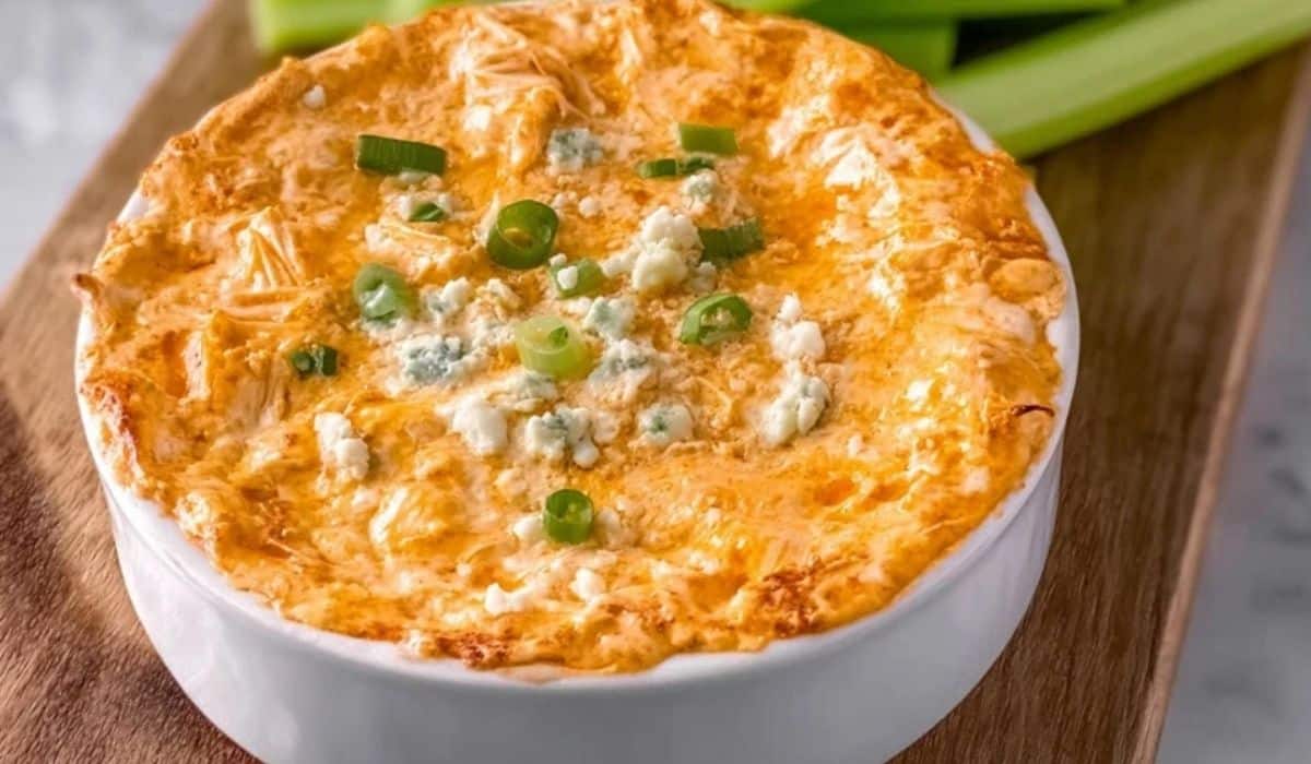 Greek Yogurt Buffalo Chicken Dip served hot in a white bowl with green onions