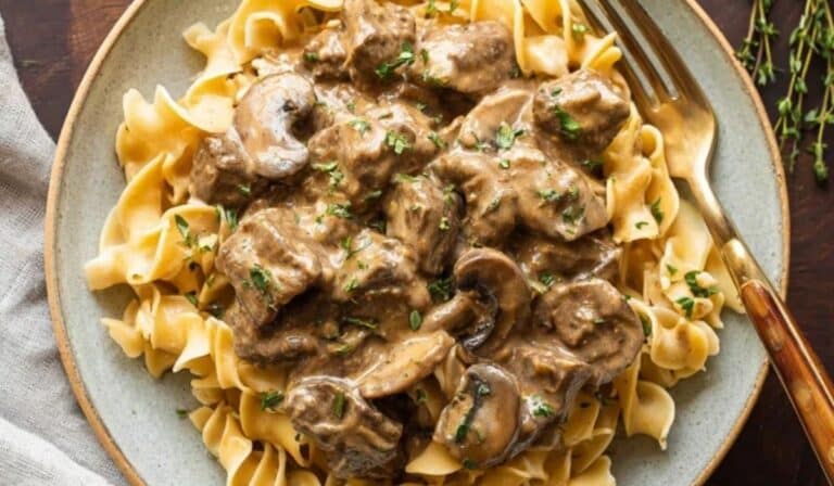 Slow Cooker Beef Stroganoff with egg noodles on a rustic plate