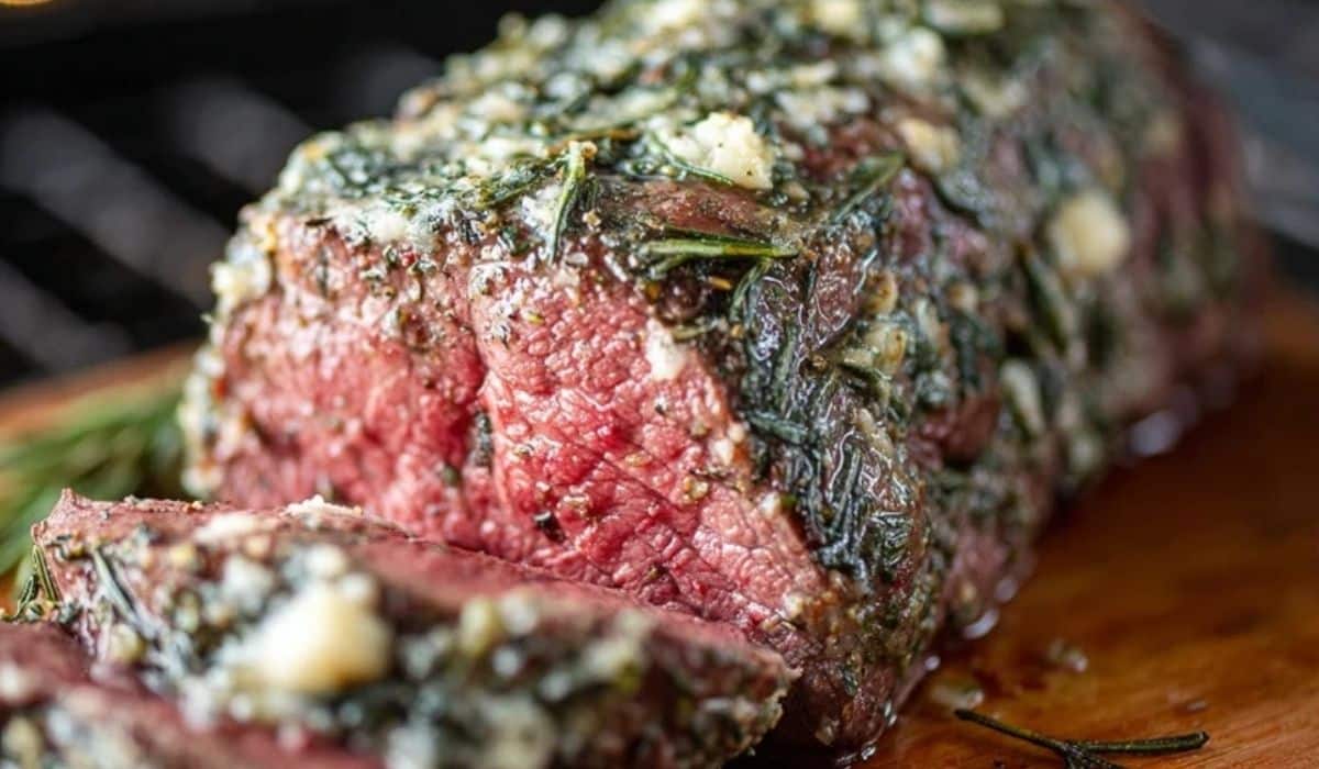 Garlic Butter Beef Tenderloin sliced on a board with butter sauce