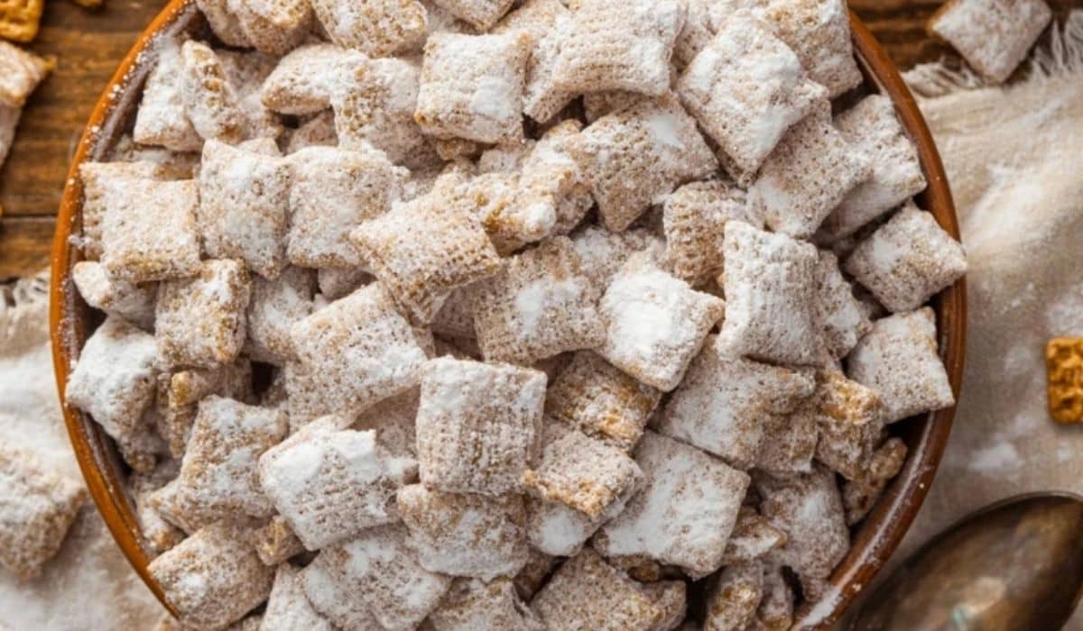 Peanut Butter Puppy Chow in a festive bowl with powdered sugar coating