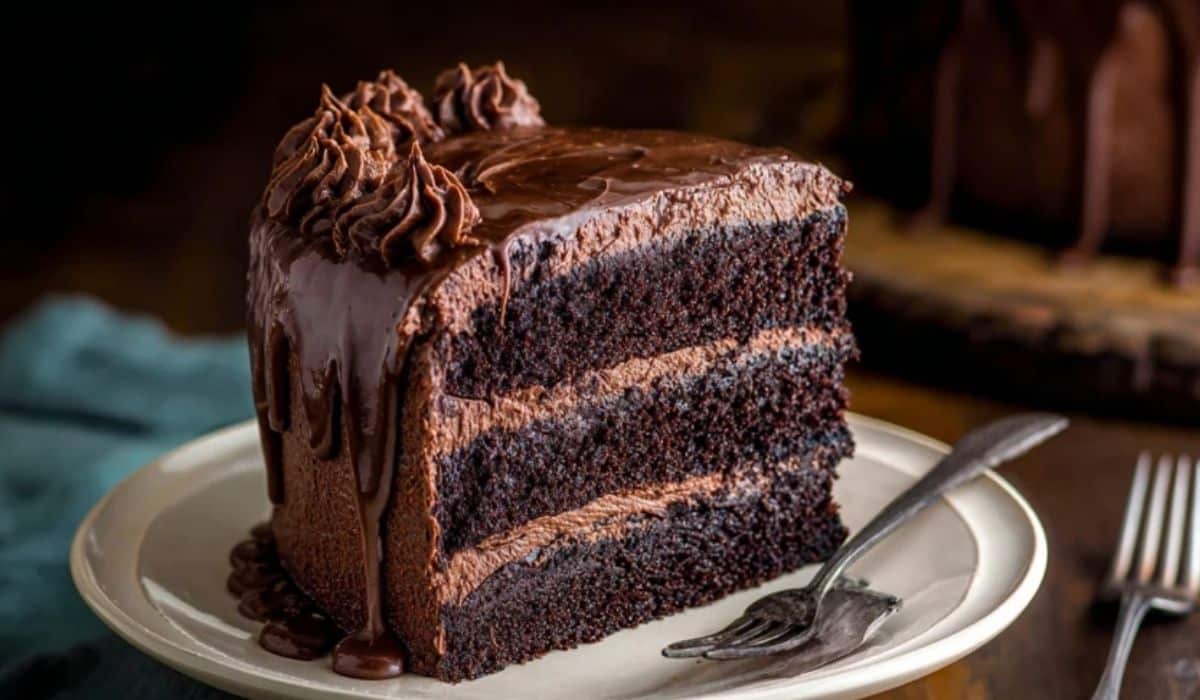 Triple Chocolate Cake on dessert stand with ganache drizzle