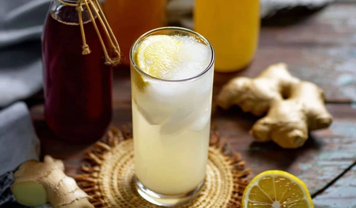 Homemade prebiotic ginger soda in a tall glass with lemon and ice