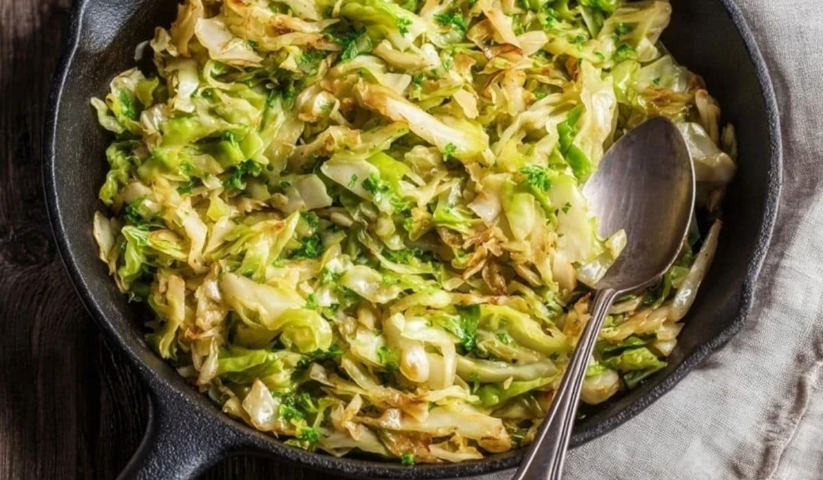Simple Sautéed Green Cabbage in a cast iron skillet with golden edges